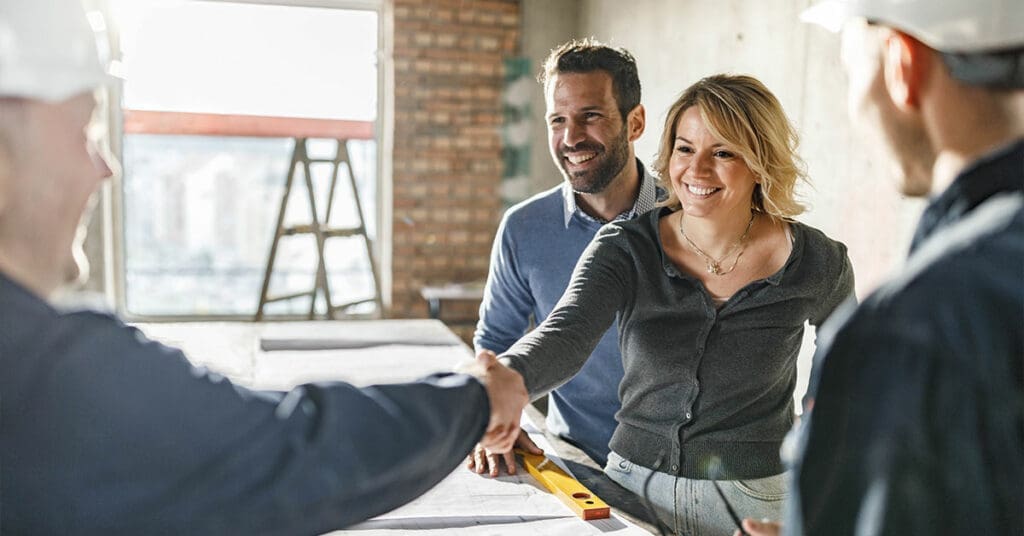 How To Choose The Right Builder 1 couple shaking hands with the builder they want to do their building or renovation project with.