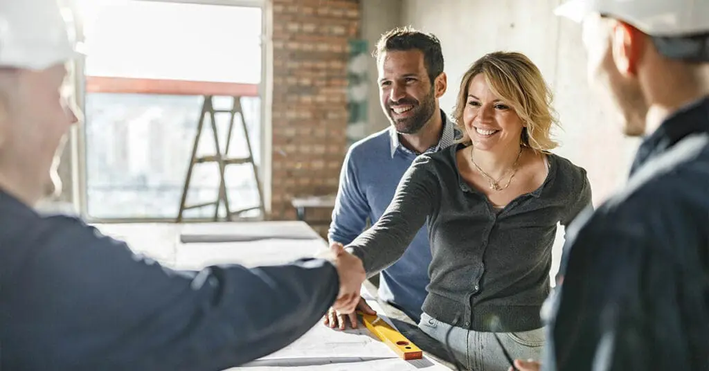 couple shaking hands with the builder they want to do their building or renovation project with.