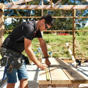 NZCB builder working at a saw horse to cut wood