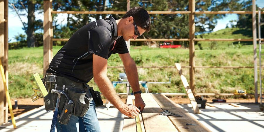 nzcb builder working at a saw horse to cut wood